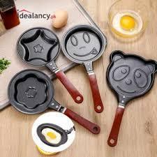 Set of non-stick mini frying pans with cute shapes for eggs or pancakes on wooden surface