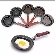 Set of nonstick mini frying pans with different shapes, wooden handles, and a fried egg